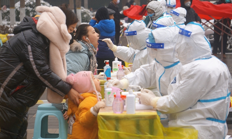Nhân viên y tế lấy mẫu xét nghiệm cho người dân ở thành phố Trịnh Châu, tỉnh Hà Nam, Trung Quốc, hôm 5/1. Ảnh: Reuters.