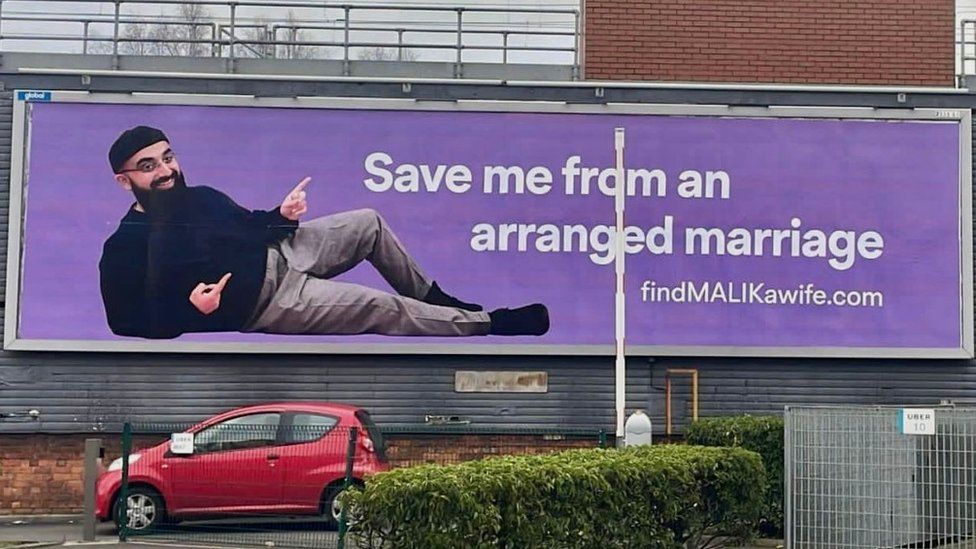 Muhammad Malik với tấm biển quảng cáo tìm vợ cỡ lớn xuất hiện tại nhiều con phố ở Anh ngày 8/1. Ảnh: CNN