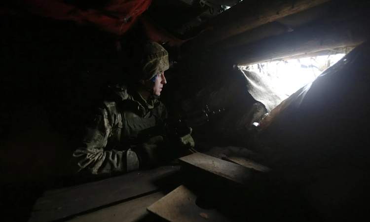 Một binh sĩ Ukraine gác tại vị trí của mình trên chiến tuyến, gần thành phố Luhansk thuộc vùng Donetsk ngày 11/1. Ảnh: AFP.
