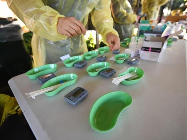 Rapid Antigen tests and timers sit on a table