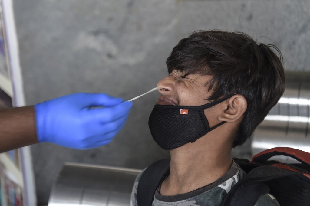 Nhân viên y tế lấy mẫu xét nghiệm Covid-19 cho người dân ở thành phố Ahmedabad, bang Gujarat, Ấn Độ hôm 25/1. Ảnh: AFP.