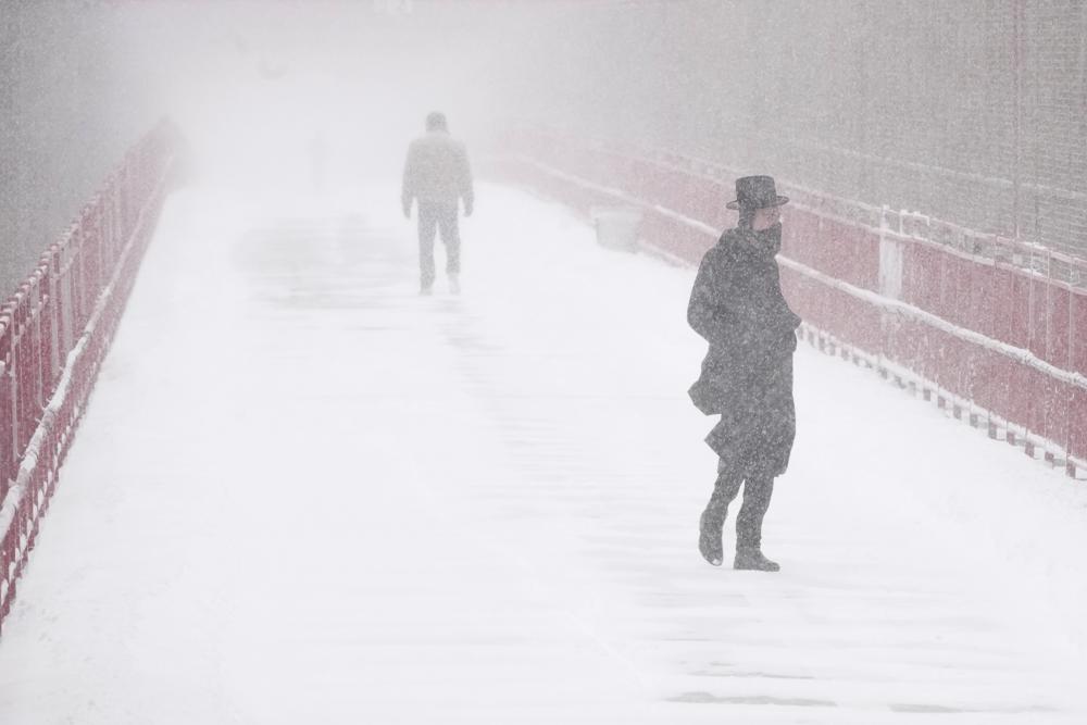 Người dân di chuyển trên cầu Williamsburg ở New York giữa bão tuyết hôm 29/1. Ảnh: AP.