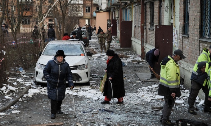 Người dân được sơ tán khỏi một tòa nhà ở Kiev, chịu hư hại sau khi trúng tập kích vào ngày 31/12. Ảnh: Reuters.