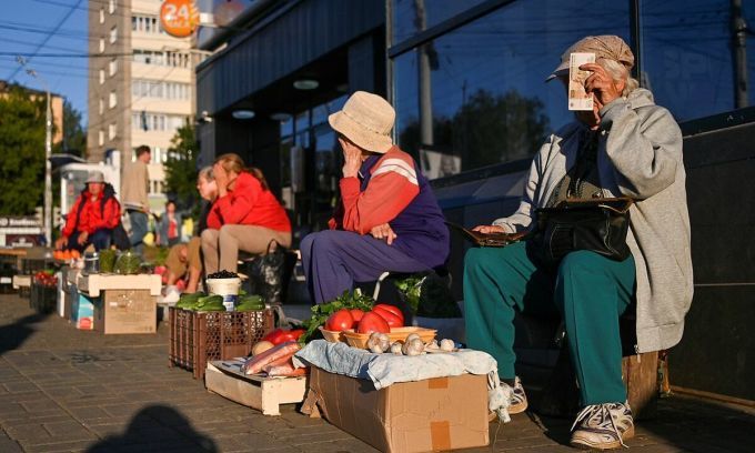 Người bán hàng ngồi trên một con phố ở Izhevsk, Nga, hồi tháng 8. Ảnh: Reuters.