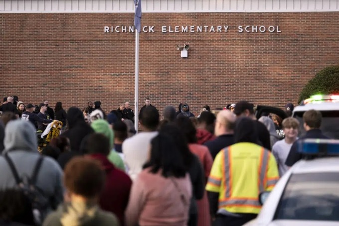 Students and police gather outside of Richneck Elementary School after a shooting, Friday, Jan. 6, 2023 in Newport News, Va. A shooting at a Virginia elementary school sent a teacher to the hospital and ended with an individual in custody Friday, police and school officials in the city of Newport News said.(Billy Schuerman/The Virginian-Pilot via AP)