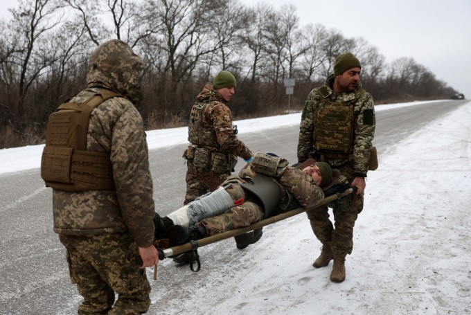 Lính quân y Ukraine cứu hộ một binh sĩ bị thương trên một con đường không xa Soledar, vùng Donetsk, ngày 14/1. Ảnh: AFP.