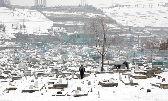 Một người đàn ông đi trong nghĩa trang phủ đầy tuyết ở thành phố Kabul, Afghanistan, hôm 11/1. Ảnh: Reuters.