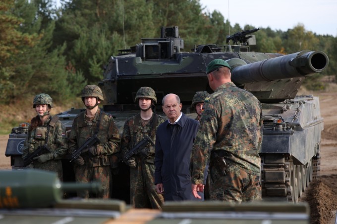 Thủ tướng Đức Olaf Scholz (áo đen) đức trước xe tăng Leopard 2 tại một cuộc tập trận ở Ostenholz, ngày 17/10/2022. Ảnh: AFP.