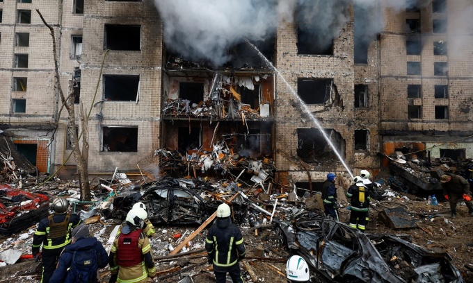 Lính cứu hỏa làm việc tại hiện trường một tòa nhà dân cư bị hư hại nặng nề trong cuộc tấn công tên lửa của Nga hôm 2/1. Ảnh: Reuters