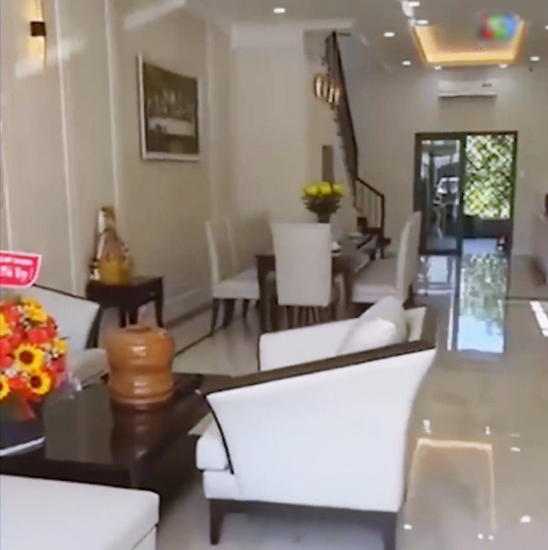 Bên trong nhà, phòng khách được bài trí khá sang trọng. Bộ sofa và bàn ghế ăn tông xuyệt tông với gam màu sáng.