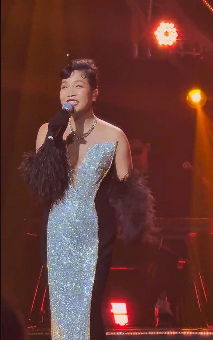 Hình ảnh mới khác lạ của ca sĩ Mỹ Linh trên sân khấu lễ trao giải tối 24.1, nữ ca sĩ diện đầm dạ hội dáng dài lấp lánh phối cùng găng tay lông màu đen yêu kiều.