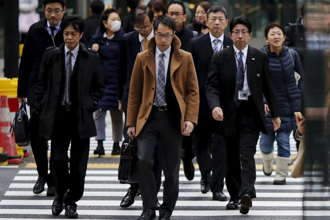 Dân công sở tản bộ trên đường phố Tokyo, Nhật Bản. Ảnh: Reuters