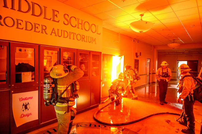 Lính cứu hỏa đối phó đám cháy lan đến một trường học ở Los Angeles hôm 10/1. Ảnh: AFP