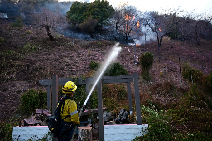 Lính cứu hỏa đang dập đám cháy ở Mandeville Canyon, hạt Los Angeles, bang California ngày 11/1. Ảnh: AFP