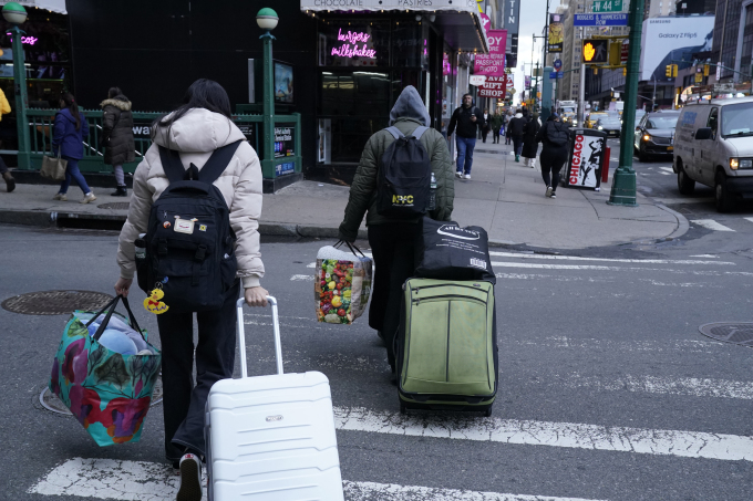 Một gia đình người nhập cư rời khỏi khách sạn ở New York City ngày 10/1/2024. Ảnh: AFP