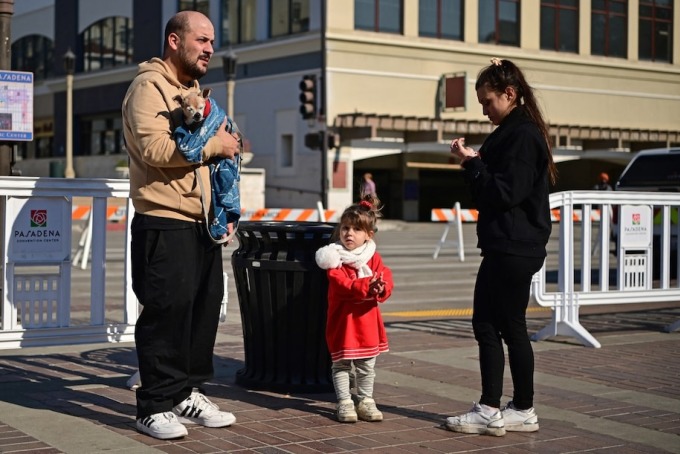 Một gia đình đem theo thú cưng tới trung tâm sơ tán ở Pasadena ngày 10/1. Ảnh: AFP