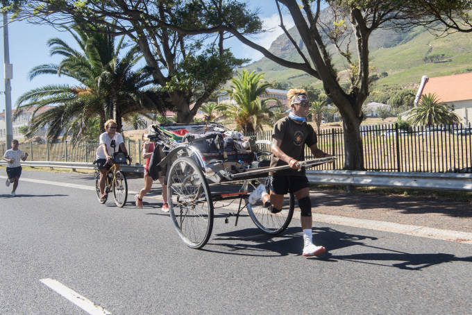 Yuji Suzuki kéo xe chạy bộ ở Cape Town, Nam Phi ngày 26/1. Ảnh: AFP