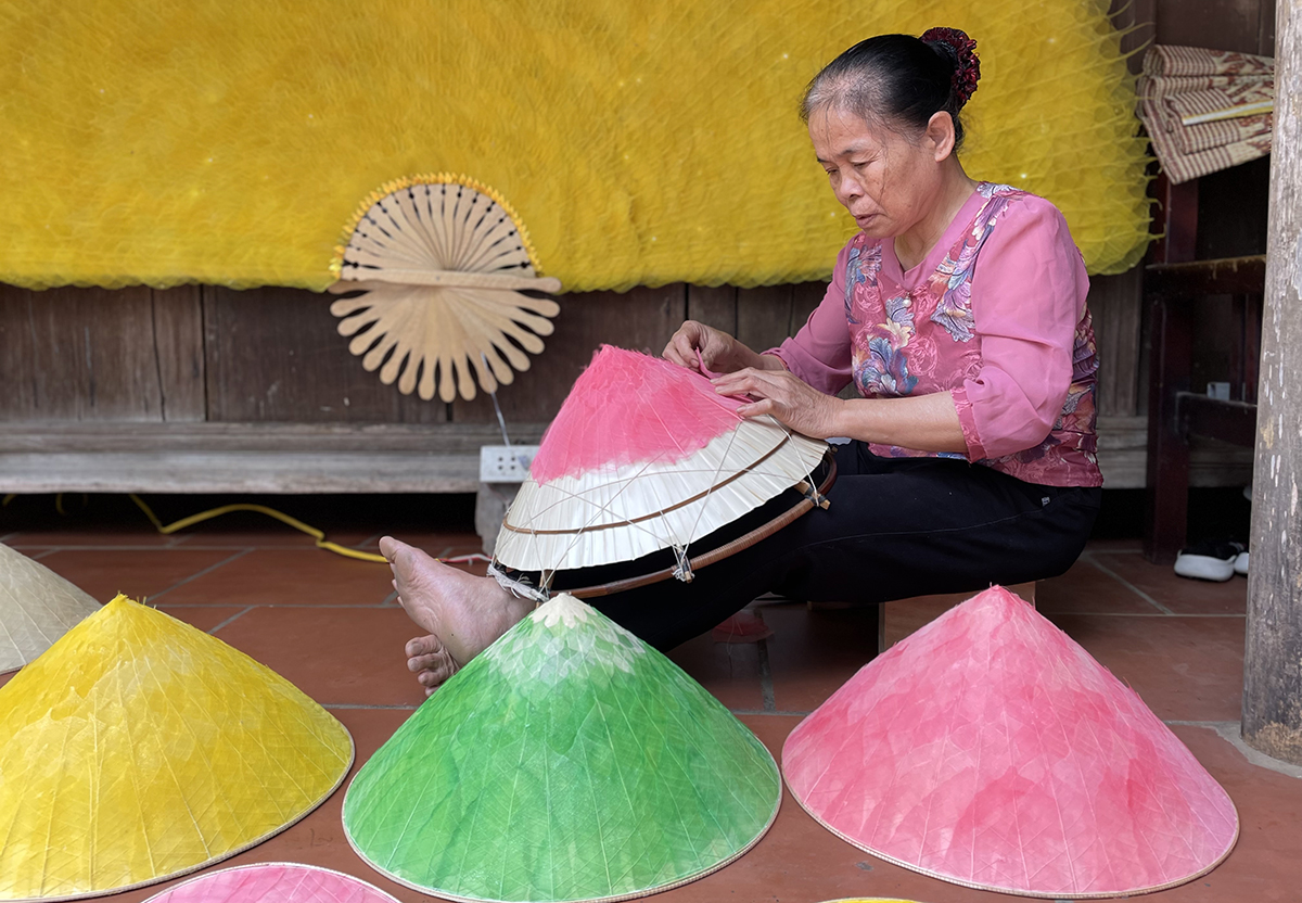 Bà Doãn Thị Thái chằm nón lá bồ đề tại nhà ở Quốc Oai một ngày cuối năm 2021. Theo bà, thời gian chằm nón lá bồ đề gấp đôi so với các nón thông thường, đổi lại bền, đẹp hơn. Ảnh: Phan Dương