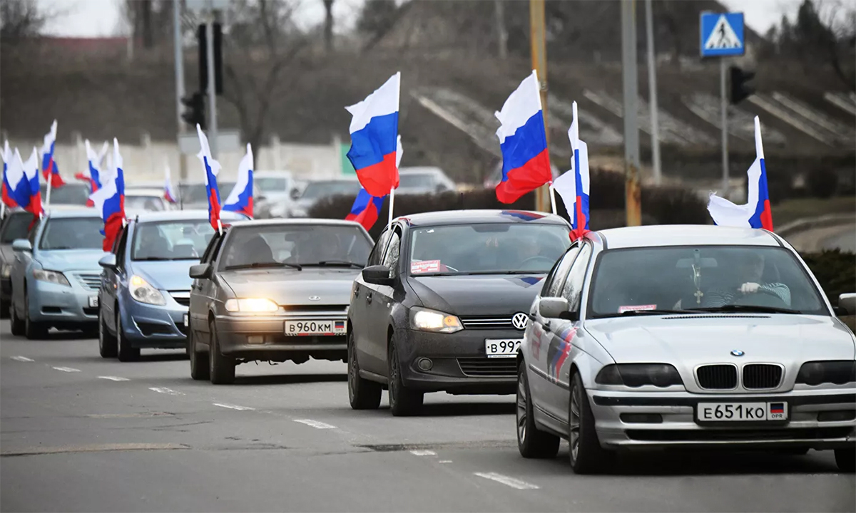 Dân thành phố Donetsk mang theo cờ Nga diễu hành trên phố ngày 22/2 sau khi Nga công nhận độc lập hai vùng ly khai ở Ukraine. Ảnh: RIA Novosti.