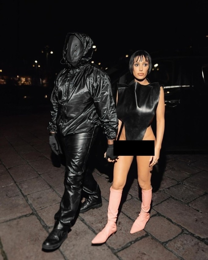 Bianca Censori để hở phần thân dưới, còn chồng mặc áo gió che kín mặt khi đi xem show Marni năm 2024. Ảnh: Backgrid