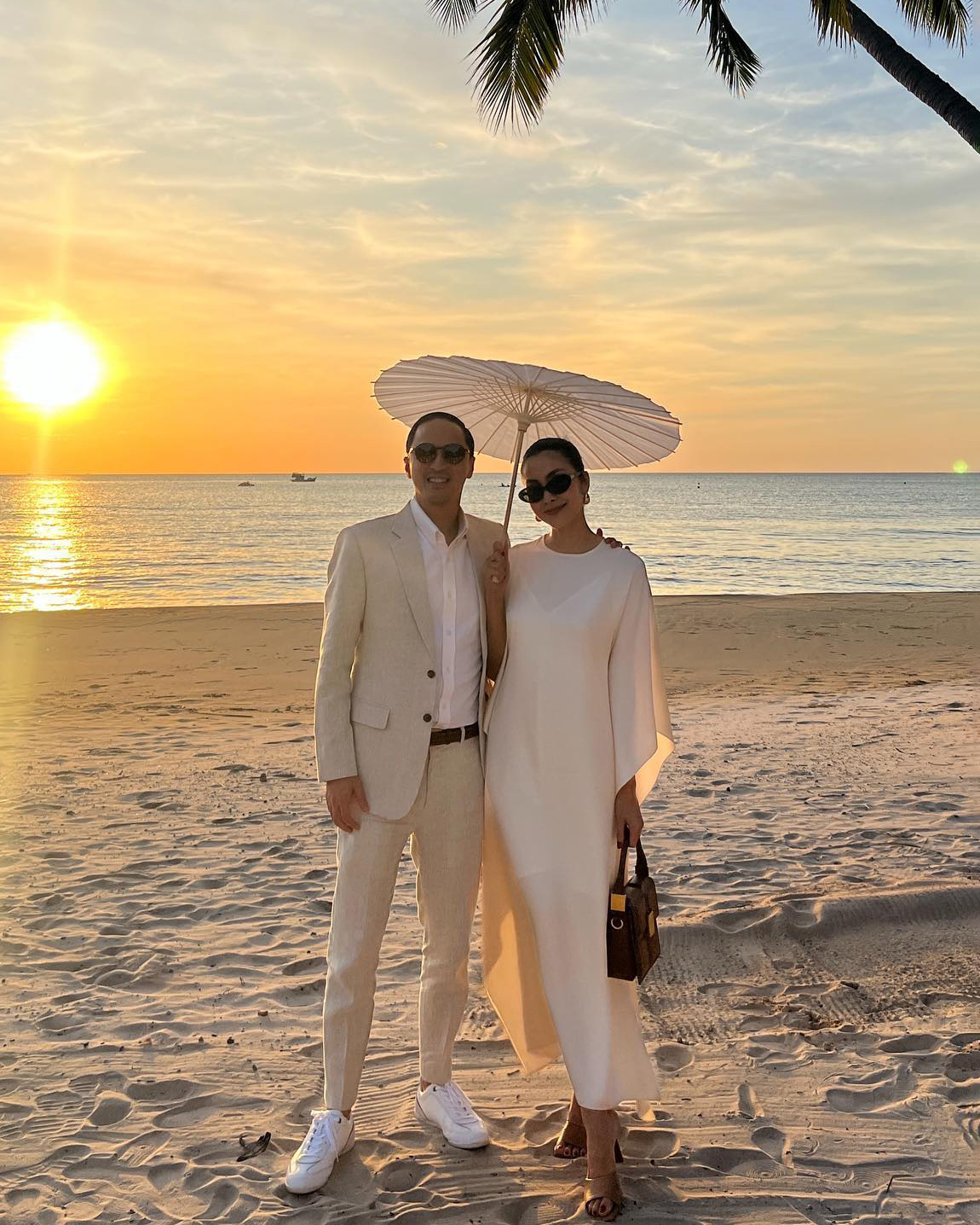 Khi dự cưới một người bạn ở biển, họ phối trang phục màu trắng kem phong cách sang trọng không phô trương.