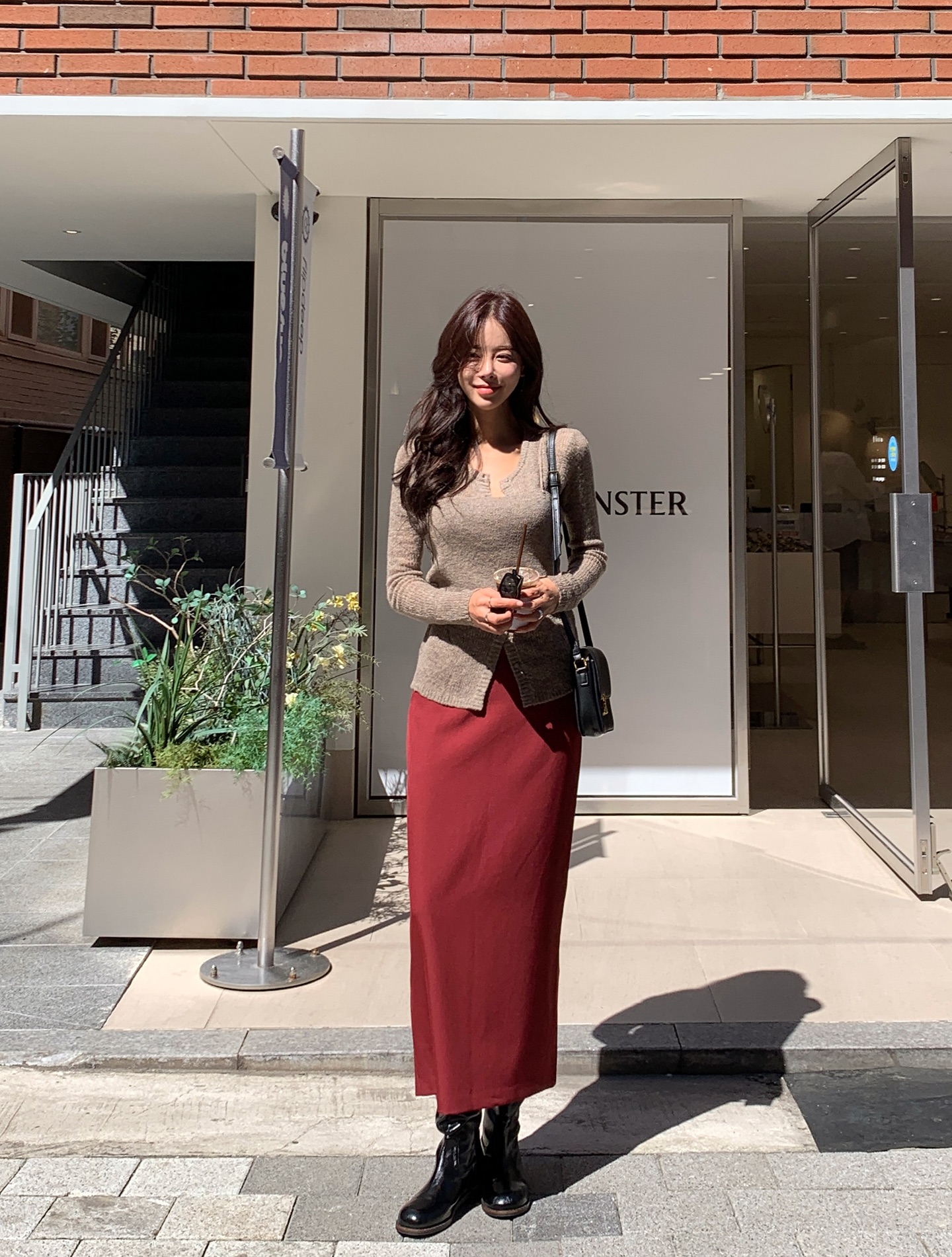 Gam màu nâu chocolate hoặc đỏ rượu mang lại cảm giác ấm áp, rất hợp không khí Tết. Chân váy tông màu này giúp outfit có điểm nhấn rõ rệt khi lên hình. Chỉ cần phối cùng áo trắng, be hoặc đen là đã đủ nổi bật mà không cần quá nhiều phụ kiện.