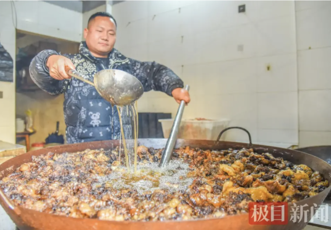 Liu Yang đang nấu mỡ bò tại một cửa hàng ở huyện Gongan. Ảnh: Jimu News