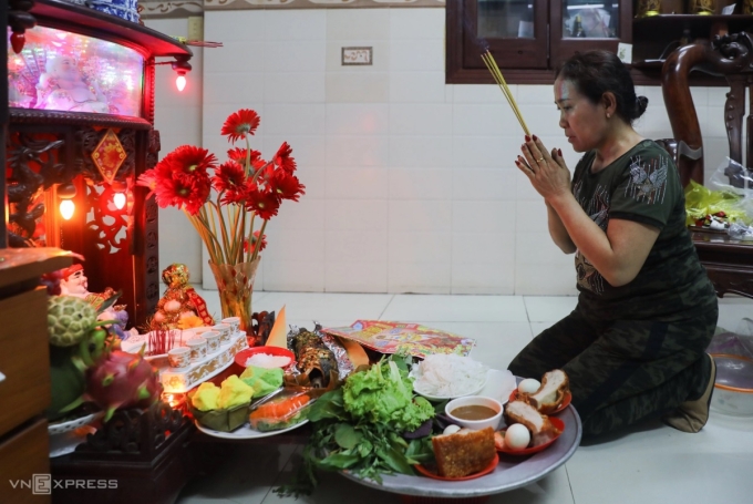 Người dân thực hiện nghi lễ cúng Thần tài. Ảnh: Quỳnh Trần