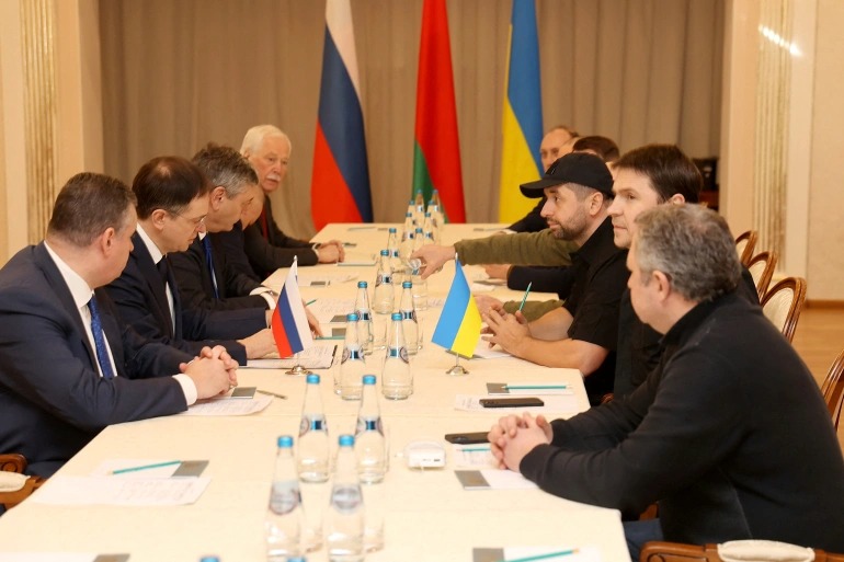 Phái đoàn Nga (trái) và Ukraine trong cuộc đàm phán ở Belarus ngày 28/2. Ảnh: Reuters.