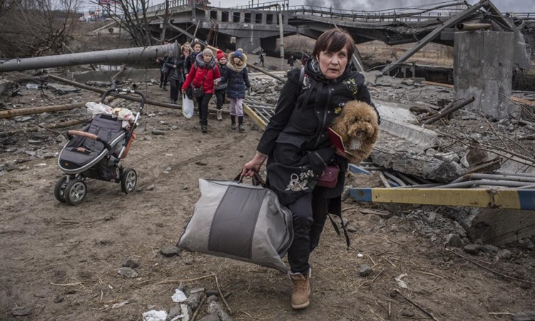 Người dân sơ tán khỏi thị trấn Irpin gần thủ đô Kiev của Ukraine ngày 6/3. Ảnh: AP.