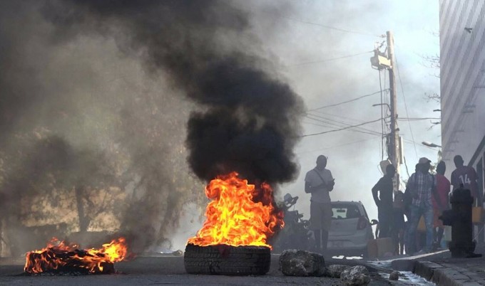Lốp xe bốc cháy gần Trung tâm Cải tạo Quốc gia ở Port-au-Prince, Haiti, ngày 3/3, sau khi hàng nghìn tù nhân vượt ngục. Ảnh: AFP