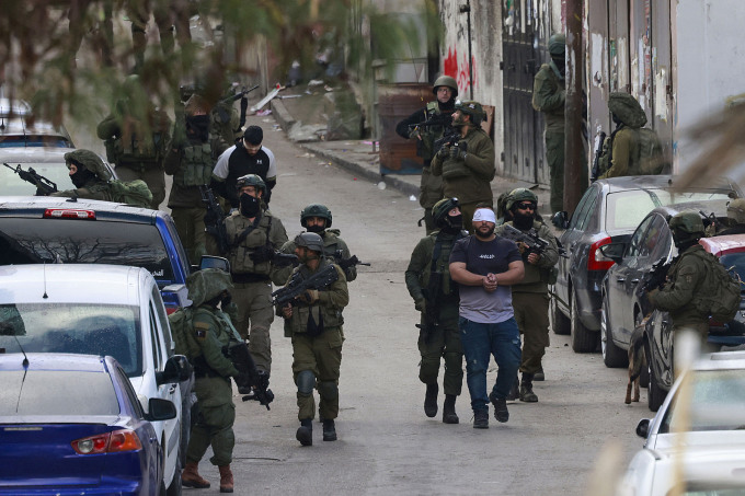 Quân đội Israel bắt người đàn ông Palestine trong cuộc đột kích vào trại tị nạn Al-Amari gần Ramallah, Bờ Tây ngày 4/3. Ảnh: AFP