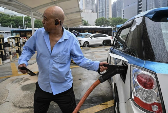 Một tài xế taxi sạc xe điện tại trạm sạc Antuoshan ở Thâm Quyến, tỉnh Quảng Đông, miền nam Trung Quốc, ngày 18/10/2023. Hector Retamal/AFP)*