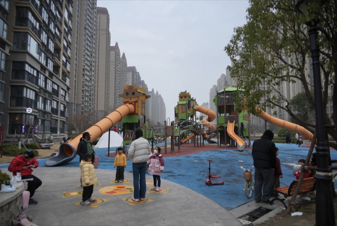 Các cư dân đưa trẻ nhỏ xuống khu vui chơi chung trong Khu đô thị Life in Venice, tỉnh Giang Tô, đầu tháng 2/2026. Ảnh: Dake Kang/AP