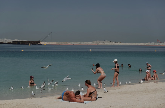 Người dân thư giãn trên bãi Kite Beach sau một vụ tấn công của Iran, diễn ra sau các cuộc không kích của Mỹ và Israel vào Iran, tại Dubai, hôm 1/3. Ảnh: Reuters.
