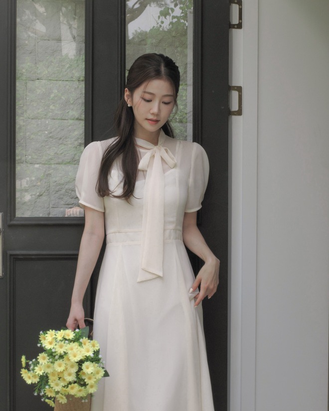 Váy trắng mang vẻ tinh khôi, thanh thoát. Thiết kế midi hoặc xòe nhẹ giúp tổng thể dịu dàng, dễ phối sandal hoặc giày cao gót.