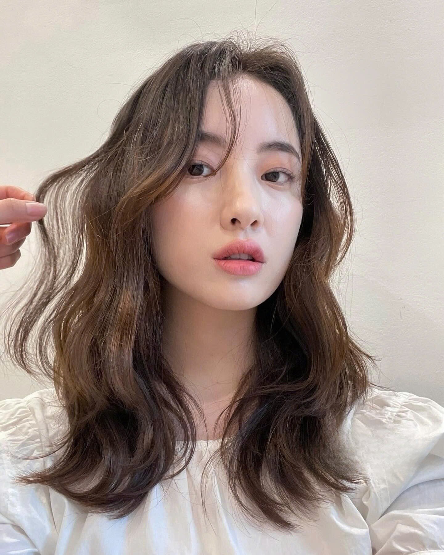 Tóc ngang vai uốn xoăn giúp mái tóc có độ phồng tự nhiên và trông dày dặn hơn. Những lọn xoăn nhẹ mang lại vẻ nữ tính, mềm mại, đồng thời giúp diện mạo trở nên nổi bật và cuốn hút.