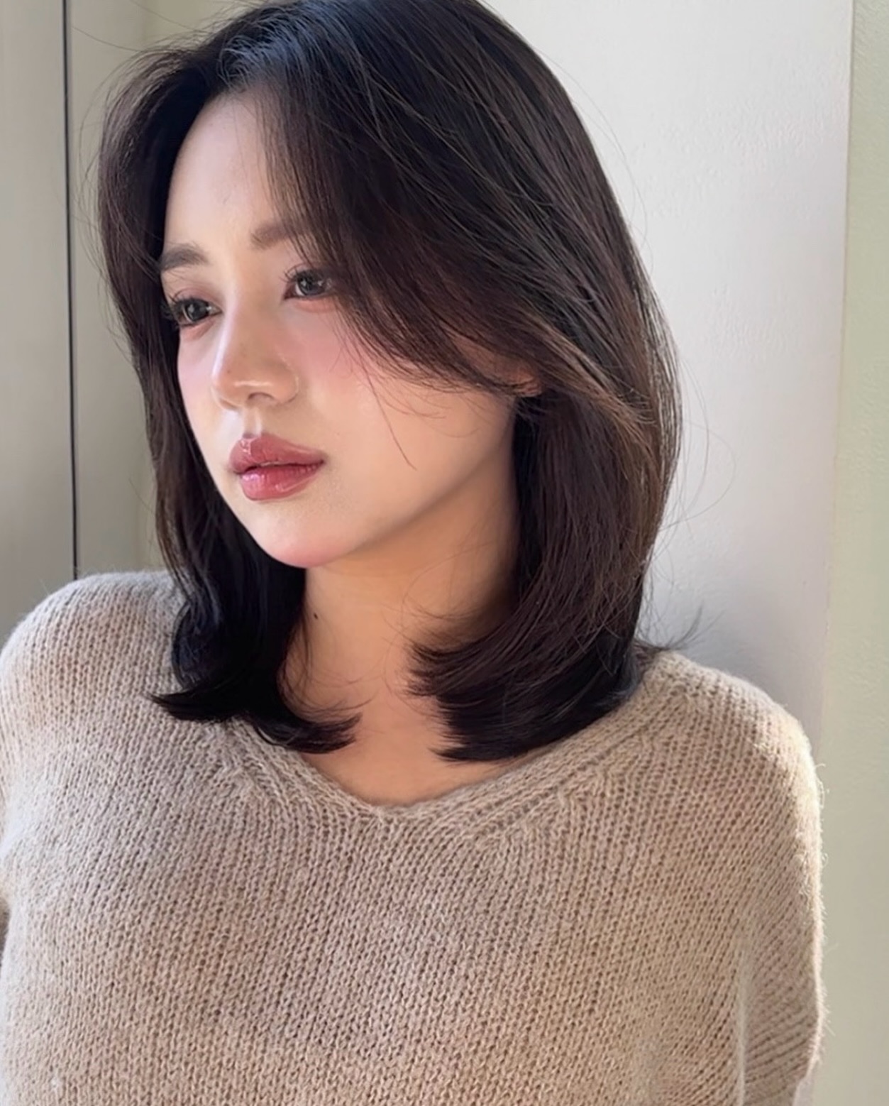 Tóc ngang vai đuôi cụp mang lại vẻ ngoài gọn gàng và nữ tính. Phần đuôi tóc được uốn nhẹ ôm vào khuôn mặt giúp tổng thể trông mềm mại hơn, đồng thời tạo hiệu ứng gương mặt thon gọn và trẻ trung hơn.