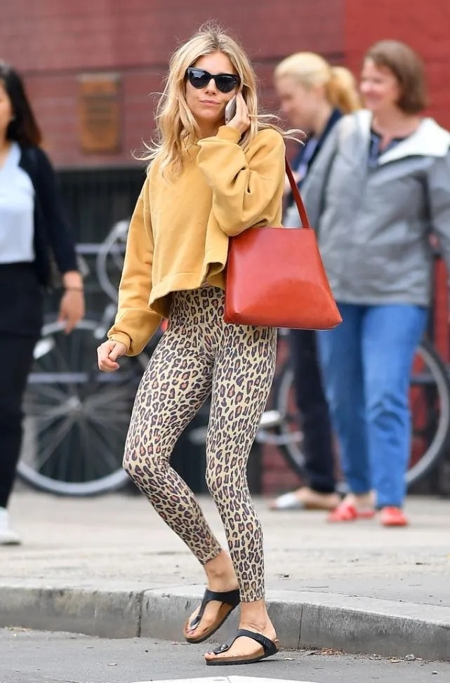 Trang phục đường phố thoải mái và phóng khoáng của diễn viên Sienna Miller, gồm quần legging, áo sweatshirt và dép xỏ ngón. Ảnh: GC Images