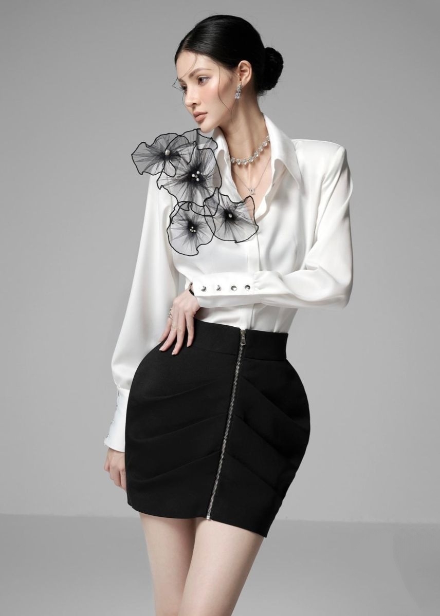 Áo đính chi tiết lớn và rườm rà như hoa vải khổng lồ, bèo nhún dày đặc tạo cảm giác nặng nề, làm mất đi sự thanh mảnh, trẻ trung.