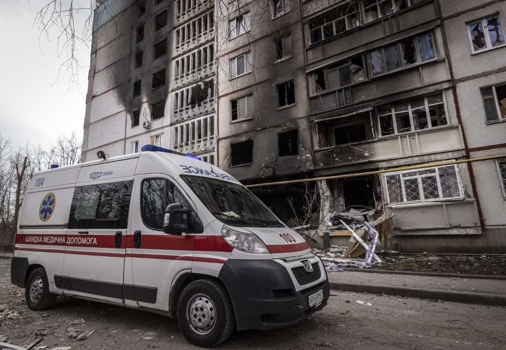 Xe cứu thương đậu gần một tòa nhà thiệt hại do giao tranh tại Kharkov, Ukraine ngày 2/4. Ảnh: AFP.