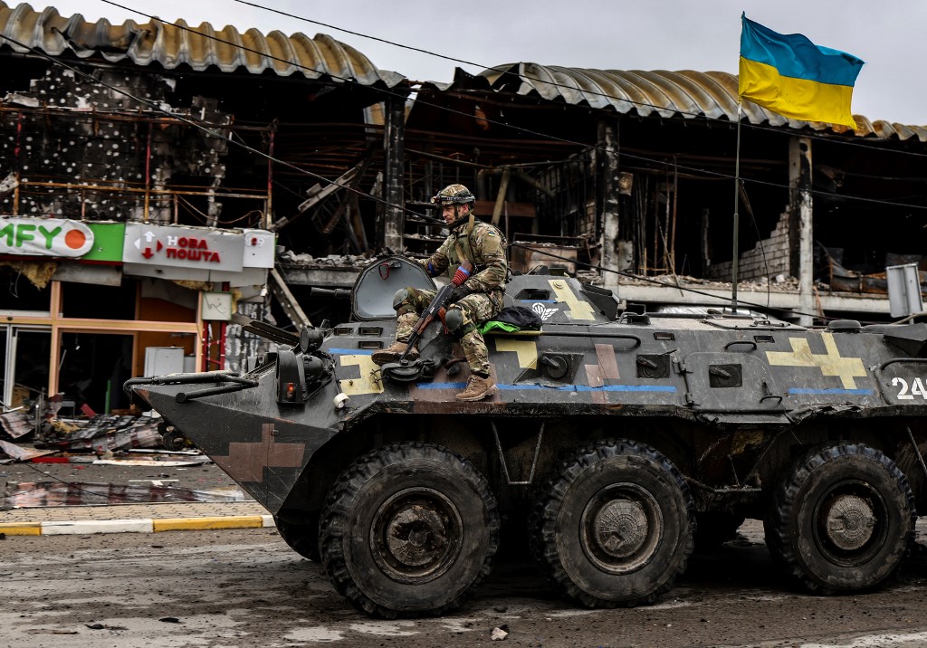 Một người lính Ukraine ngồi xe thiết giáp đi trên đường phố Bucha, tây bắc Kiev, ngày 2/4. Ảnh: AFP