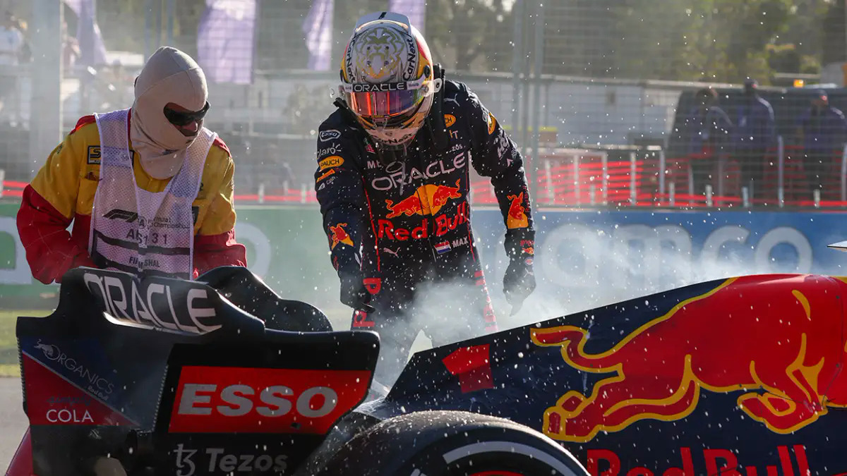 Verstappen chỉ vị trí nghi rò rỉ nhiên liệu trên chiếc RB18 để nhân viên đường đua xịt bình cứu hoả, sau khi anh bỏ cuộc tại Grand Prix Australia ngày 10/4. Ảnh: AP