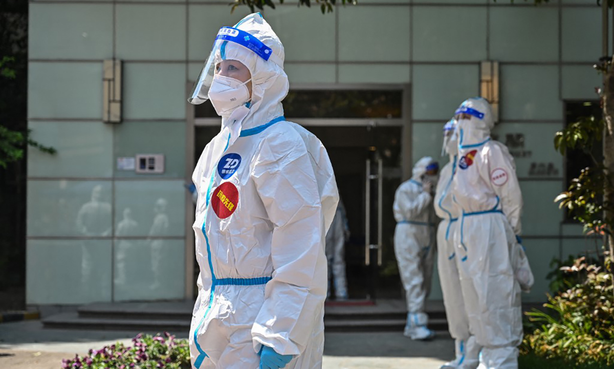 Nhân viên y tế và tình nguyện viên bên ngoài điểm lấy mẫu xét nghiệm Covid-19 tại Thượng Hải, Trung Quốc ngày 6/4. Ảnh: AFP.
