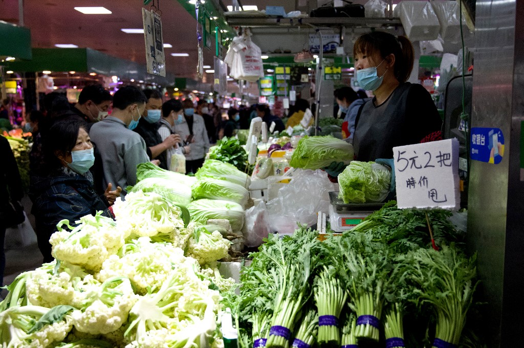 Người dân mua rau củ tại một khu chợ ở Bắc Kinh hôm 14/4. Ảnh: AFP