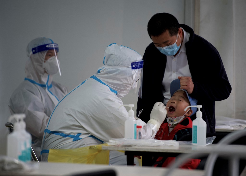 Nhân viên y tế lấy mẫu xét nghiệm Covid-19 cho bé trai ở Bắc Kinh, Trung Quốc hôm 25/4. Ảnh: AFP.