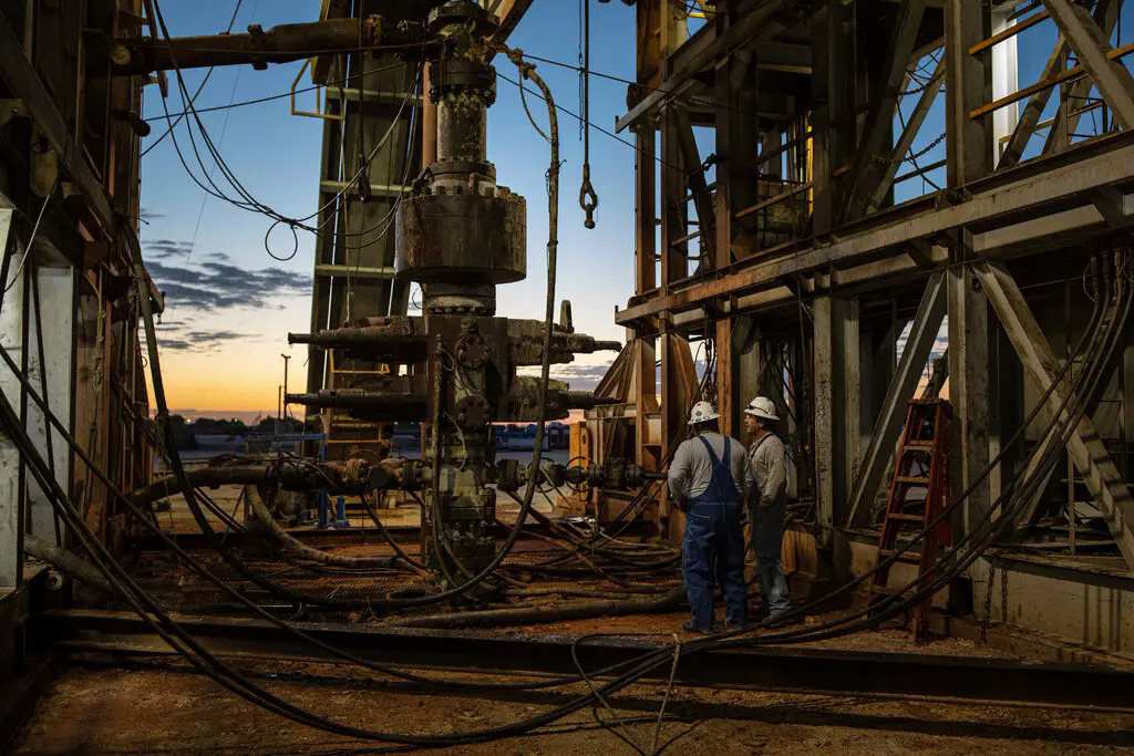 Hai nhân viên kiểm tra giàn khoan dầu gần thành phố Stanton, hạt Martin, bang Texas, tháng 4/2020. Ảnh: New York Times.
