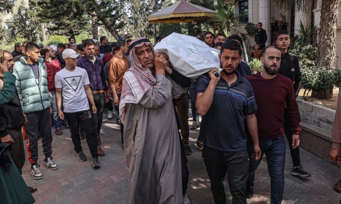 Người thân khiêng thi thể một nhân viên thuộc tổ chức Bếp ăn Trung tâm Thế giới thiệt mạng trong cuộc không kích của Israel. Ảnh: AFP