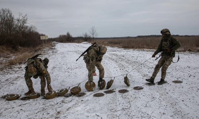 Binh sĩ Ukraine gài lại mìn sau khi đoàn xe trở về. Ẩnh: Telegraph
