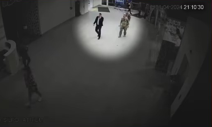 Các sĩ quan tuyển quân tiếp cận nhà báo Shulhat (áo đen) trong video do camera an ninh quay. Ảnh chụp màn hình